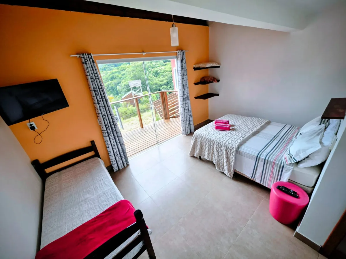 Céu Azul: quarto com cama de casal, cama de solteiro e porta de vidro para a varanda com vista para a mata