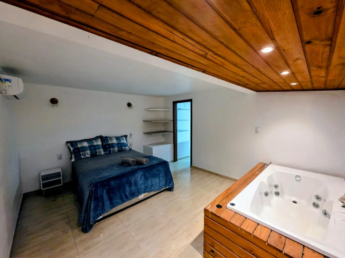 Refúgio dos Pássaros: suíte com cama de casal, banheira de hidromassagem e teto de madeira